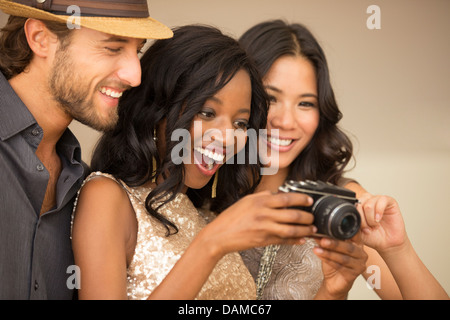 Friends using camera at party Stock Photo