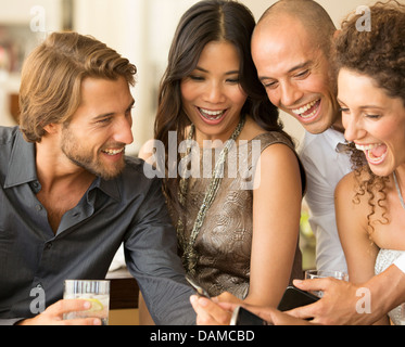 Friends using cell phones at party Stock Photo