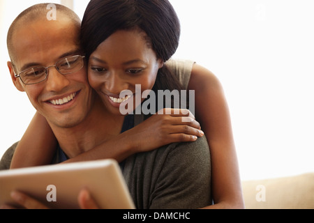 Couple using tablet computer on sofa Stock Photo