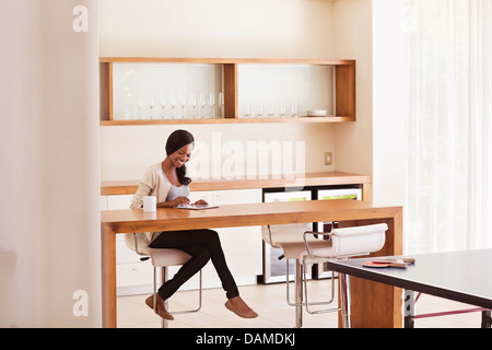 Woman using tablet computer at table Stock Photo