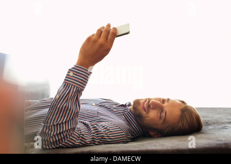 Man using cell phone on bench Stock Photo