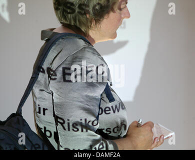 The letters 'EHEC' (dangerous strain of E. Coli) is projected onto the skin and clothes of a journalist at the Federal Institute for Risk Assessment (BfR) after a press conference in Berlin, Germany, 10 June 2011. The Robert Koch Institute, the Federal Institute for Consumer Protection and Food Safety and the Federal Institute for Risk Assessment have announced that the existing re Stock Photo