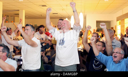 Father of German basketball player Dirk Nowitzki from the Dallas Mavericks, Joerg Nowitzki, celebrates during live coverage of game 6 of the NBA Finals at a bar in Wuerzburg, Germany, 13 June 2011. German player Dirk Nowitzki and his team the Dallas Mavericks won 105:95 and claimed the series 4:2. Photo: Daniel Karmann Stock Photo