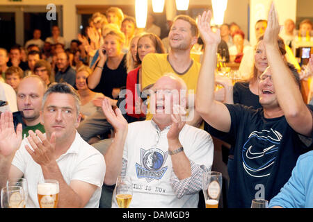 Father of German basketball player Dirk Nowitzki from the Dallas Mavericks, Joerg Nowitzki (C), celebrates the Mavericks victory during live coverage of game 6 of the NBA Finals at a bar in Wuerzburg, Germany, 13 June 2011. German player Dirk Nowitzki and his team the Dallas Mavericks won 105:95 and claimed the series 4:2. Photo: Daniel Karmann Stock Photo