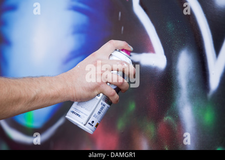 A close up photograph of a graffiti artist holding an aerosol can of ...