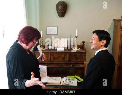 Japanese Crown Prince Naruhito visits the Mori Ogai memorial with the co-director of the site, Beate Wonde, in Berlin, Germany, 22 June 2011. A replica of the death mask of Japanese doctor and poet Mori Ogai (1862-1922) that was made by sculptor Shinkai Chikutaro (1868-1927) hangs on the wall. Naruhito is on a visit to Berlin. Photo: CLEMENS BILAN Stock Photo