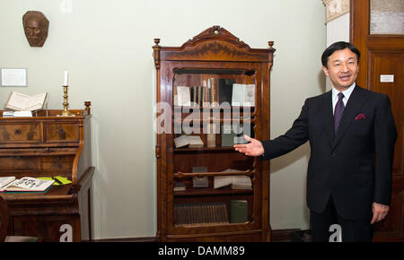 Japanese Crown Prince Naruhito visits the Mori Ogai memorial with the co-director of the site, Beate Wonde, in Berlin, Germany, 22 June 2011. A replica of the death mask of Japanese doctor and poet Mori Ogai (1862-1922) that was made by sculptor Shinkai Chikutaro (1868-1927) hangs on the wall. Naruhito is on a visit to Berlin. Photo: CLEMENS BILAN Stock Photo