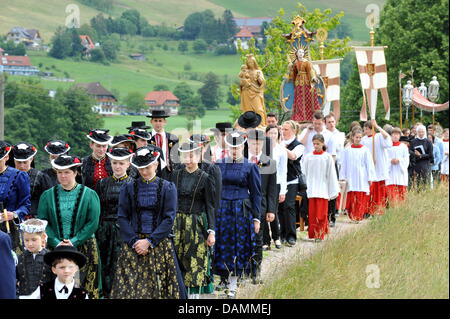 Believers dressed in traditional clothing  accompany the Corpus Christi procession, a Catholic tradition in the Black Forest region near St Peter, Germany, 23 June 2011. After a festive church service the procession moved through the local area praying and singing, accompanied by a local music band.    Photo: Rolf Haid Stock Photo