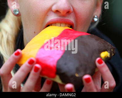 16-year-old soccer fan and player Jule takes a bite of a German World Cup barm in Muelheim, Germany, 25 June 2011. On 26 June, Germany and Canada play the FIFA Women's World Cup opening match in Berlin. Photo: Roland Weihrauch Stock Photo