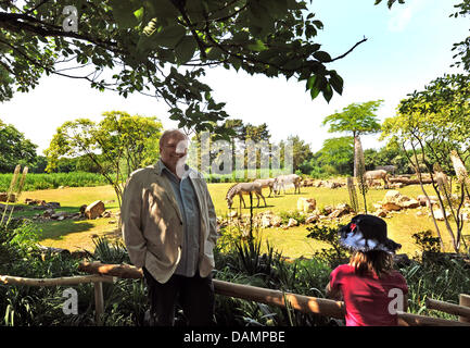 Zoo director Dr. Joerg Junhold stands in front of an outdoor enclosure of the zoo in Leipzig, Germany, 3 June 2011. Among others the enclosure, that has been recreated in the African savannah landscape, hosts Rothschild giraffes, Grevy zebras, sable antelopes and Thomson gazelles. The animals are presented at the so-called zoo's showcase and can be viewed from outside. The zoo was  Stock Photo