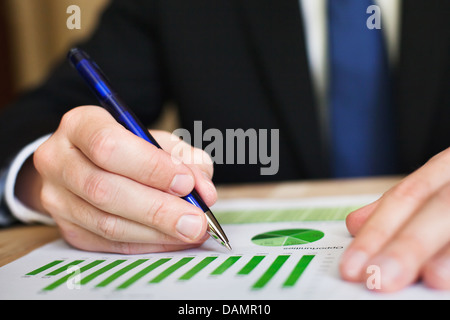 Businessman analyzes a successful sustainable development on a bar chart Stock Photo