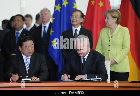 Volkswagen (VW) CEO Martin Winterkorn (FROMT R) and Shanghai Automotive Industry Corporation (SAIC) CEO, Hu Maoyuan (FRONT L), sign a framework contract for investments at the Federal Chancellery in Berlin, Germany, 28 June 2011. China's Premier Wen Jiabao (BACK 2nd to R) and German Chancellor Angela Merkel (R) stand in the back. They meet for German-Chinese Government Consultation Stock Photo