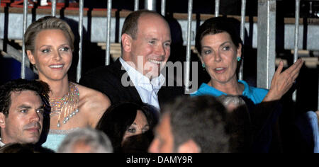 The newly-wed couple Prince Albert II of Monaco and his wife Princess Charlene together with his sister Princess Caroline of Hanover (r) attend a music and light show performed by French composer and musician Jean-Michel Jarre to celebrate the royal wedding at Port Hercules, in Monaco, 01 July 2011. Photo: Jochen Lübke dpa Stock Photo