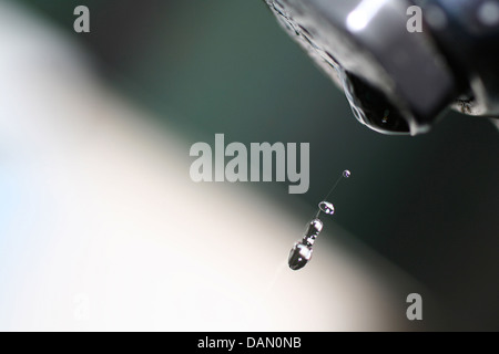 A water droplet falling from a tap. Stock Photo