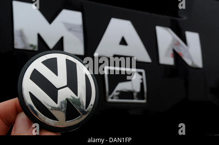 (ILLUSTRATION) An archive illustration dated 04 July 2011 shows the logo of Volkswagen being held in front of the logo of MAN on a truck in Hanover, Germany, 04 July 2011. Volkswagen has acquired 55.9 percent of the truck manufacturer MAN, according to VW. Photo: Julian Stratenschulte Stock Photo