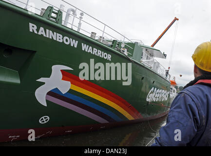 A worker watches the new Greenpeace ship 'Rainbow Warrior III' being elevated into the water at the Fassmer Wharf in Berne, Germany, 04 July 2011. In October 2011, its construction is said to be finished. Photo: Caroline Seidel Stock Photo
