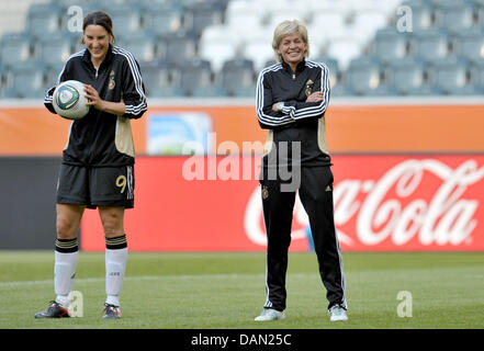 Coach of the German women's national soccer team, Silvia Neid (R), and her player Birgit Prinz stand on the pitch during the practice session of the German squad in  Moenchengladbach, Germany, 04 July 2011. The FIFA Women's World Cup takes place in Germany from 26 June to 17 July 2011. Photo: Carmen Jaspersen Stock Photo