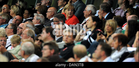 German chancellor Angela Merkel (in red) watches the Group C match Sweden against USA of FIFA Women's World Cup soccer tournament at the Arena Im Allerpark, Wolfsburg, Germany, 06 July 2011. Foto: Julian Stratenschulte dpa/lni Stock Photo