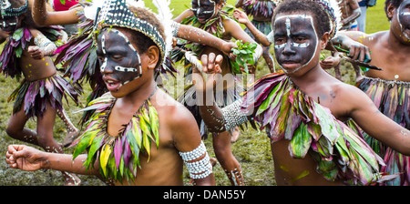 Children wearing traditional leaf costumes and dancing at the Goroka show in Papua New Guinea. Stock Photo