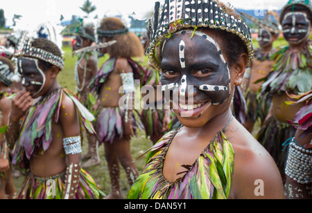 Children wearing traditional leaf costumes and dancing at the Goroka show in Papua New Guinea. Stock Photo