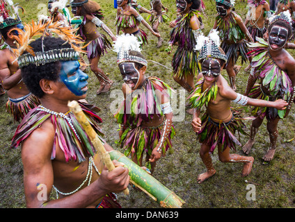 Children wearing traditional leaf costumes and dancing at the Goroka show in Papua New Guinea. Stock Photo