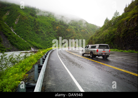 Cars and trucks on wet and rainy Highway 4, Richardson Highway, near Bridal Veil and Horse Tail Falls, near Valdez, Alaska, USA Stock Photo