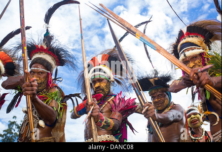 Looking up at a group of tribal warriors with drawn bow and arrows, Papua New Guinea Stock Photo