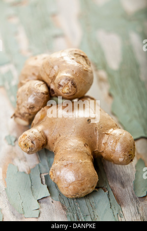 Two fresh whole ginger roots on a cracked painted wood surface. Stock Photo