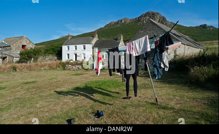 Clothes and wetsuits hanging on washing line outside St. David's Youth Hostel in summer at Whitesands Bay Pembrokeshire Wales UK Stock Photo