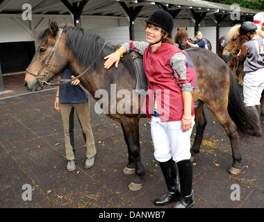 Singer Edita Abdieski pets a horse at the benefit race day for the child protection alliance (Kinderschutzbund) of Cologne at the horse track in Cologne, Germany, 10 July 2011. It is the tenth time that celebrities have helped the child protection alliance by collecting donations. Photo: HENNING KAISER Stock Photo