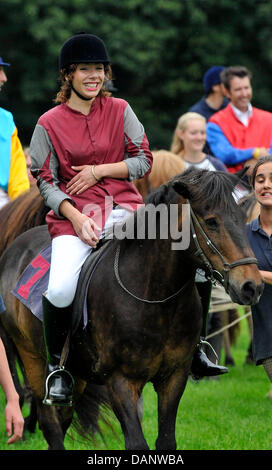 Singer Edita Abdieski sits on a horse after the race at the benefit race day for the child protection alliance (Kinderschutzbund) of Cologne at the horse track in Cologne, Germany, 10 July 2011. It is the tenth time that celebrities have helped the child protection alliance by collecting donations. Photo: HENNING KAISER Stock Photo