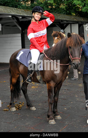 Actress Marylu Poolman sits on a horse at the benefit race day for the child protection alliance (Kinderschutzbund) of Cologne at the horse track in Cologne, Germany, 10 July 2011. It is the tenth time that celebrities have helped the child protection alliance by collecting donations. Photo: HENNING KAISER Stock Photo