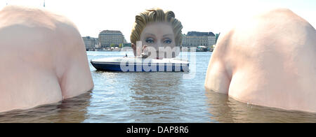 Advertising agency owner Oliver Voss and the sculpture sponsor and owner of the English cosmetics company 'Soap & Glory', Marcia Kilgore, ride in a pedal boat up to the sculpture of a giant mermaid in the Inner Alster in Hamburg, Germany, 02 August 2011. The sculpture made by the artist and owner of an advertising agency Oliver Voss shall be in the inner Alster for the next ten day Stock Photo