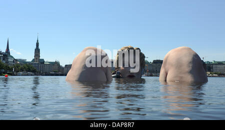 Day-trippers ride in a Tboat up to the sculpture of a giant mermaid in the Inner Alster in Hamburg, Germany, 02 August 2011. The sculpture made by the artist and owner of an advertising agency Oliver Voss shall be in the inner Alster for the next ten days. Photo: MARCUS BRANDT Stock Photo