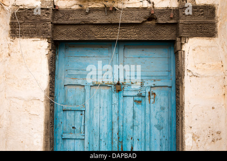 Africa, Eritrea, Massawa, Old Town, blue painted door and carved decorated lintel of dilapidated building Stock Photo