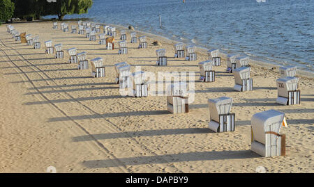 Beach chairs cast long shadows at the lido Wannsee in Berlin, Germany, 09 August 2011. Photo: Jens Kalaene Stock Photo