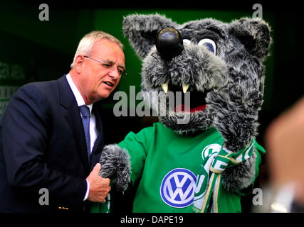 Chairman of the board of Volkswagen AG, Martin Winterkorn (L), shakes hands as he talks to the mascot of Bundesliga soccer club VfL Wolfsburg, 'Woelfi', during the Bundesliga soccer match between  VfL Wolfsburg and FC Bayern Munich at the Volkswagen Arena soccer stadium in Wolfsburg, Germany, 13 August 2011. Photo: Julian Stratenschulte Stock Photo