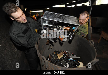 A file picture taken on 30 March 2009 shows employees of an explosives removal squad who melt weapons into an oven in Sindelfingen, Germany. Weapons that were turned in, also subsequent to a call after the amok shooting in Winnenden and Wendlingen, were destroyed by the squad. The event takes place regularly. Since the amok shootings in March 2009, 120 000 weapons were turned in ou Stock Photo