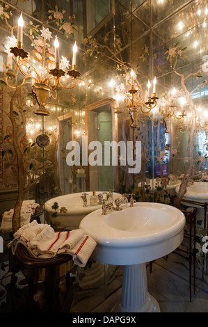 Bathroom with mirror-lined walls and ceiling and Bagues rock-crystal sconces. Stock Photo
