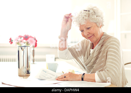 Grandma at home busy reading something Stock Photo