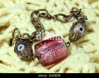 Bracelet handmade from Murano glass on the knitted scarf Stock Photo