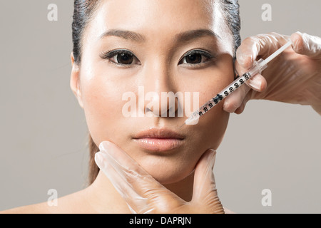 Chinese woman receiving a botox injection. Beauty Treatment. Stock Photo