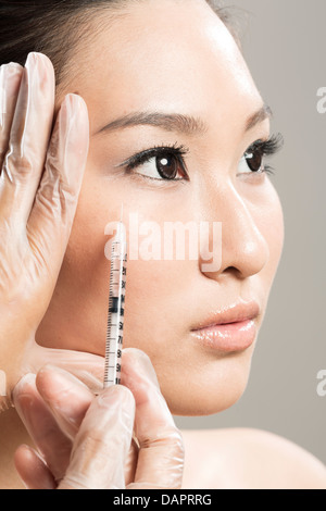 Chinese woman receiving a botox injection. Beauty Treatment. Stock Photo