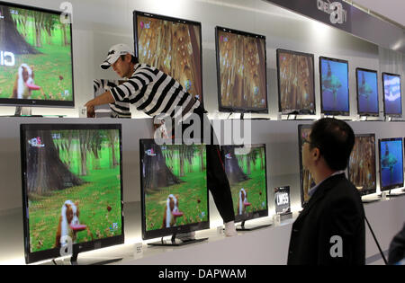 A technician installs 3D televisions at the trade fair IFA in the trade fair halls under the radio tower in Berlin, Germany, 01 september 2011. The trade show for consumer electronics and home appliance (IFA) is open from 02 until 09 September. Photo: WOLFGANG KUMM Stock Photo