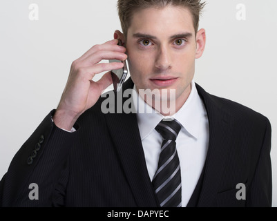 Businessman in suit and tie using Apple iPhone Stock Photo