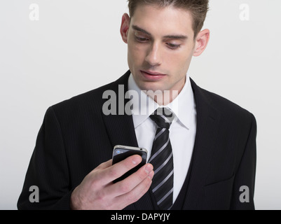 Businessman in suit and tie texting on his phone Stock Photo