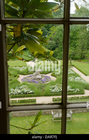 View through window to garden with box hedge borders and statue, Ampney Park, 17th century English country house Stock Photo