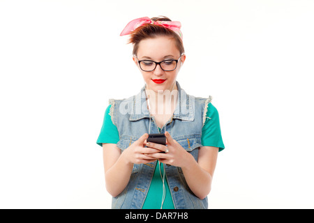 Teenage girl, dressed casually, poses holding an iphone listening to music, talking on the phone and taking pictures of herself. Stock Photo