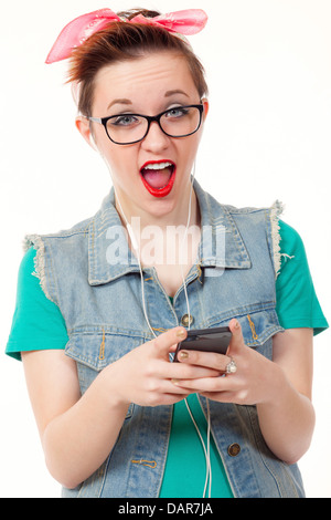 Teenage girl, dressed casually, poses holding an iphone listening to music, talking on the phone and taking pictures of herself. Stock Photo