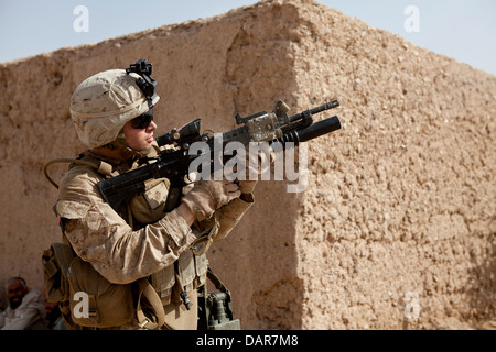 A US Marine fires an M203 grenade launcher while coming under fire from insurgents during a cordon and search mission June 27, 2013 in Habib Abad, Helmand province, Afghanistan. Stock Photo